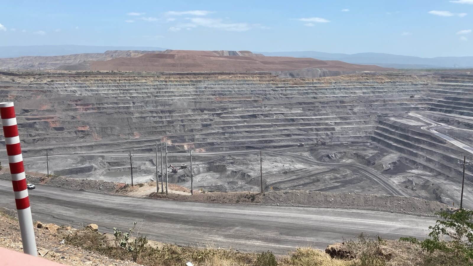 Terraced open-pit mine in Cesar with power lines already running through the pit