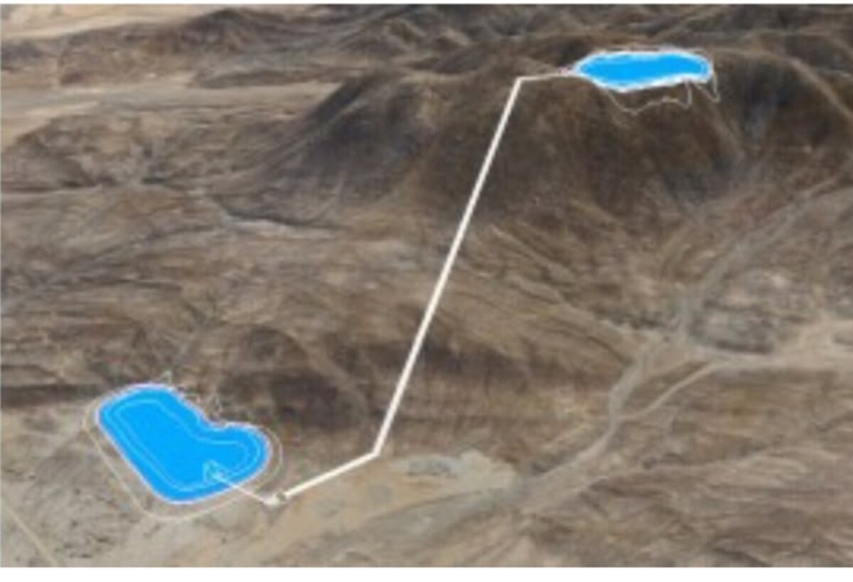Aerial view of an operating pumped hydro plant: upper and lower reservoir connected by a penstock